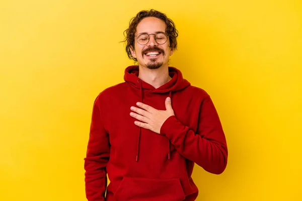 Νεαρός Καυκάσιος Άνδρας Απομονωμένος Κίτρινο Φόντο Γελάει Δυνατά Κρατώντας Χέρι — Φωτογραφία Αρχείου