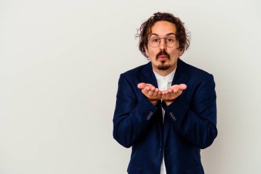 Genç iş adamı beyaz arka planda izole edilmiş dudakları kıvrılmış ve hava öpücüğü vermek için avuç içleri tutulmuş..