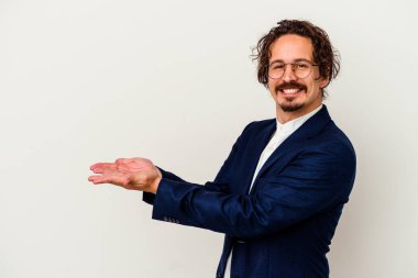 Beyaz arka planda izole edilmiş genç bir iş adamı avucunun içinde bir kopya alanı tutuyor..