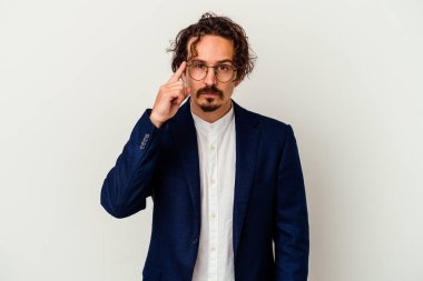 Genç iş adamı beyaz arka planda izole edildi. Şakağı parmağıyla göstererek, düşünerek, bir göreve odaklandı..