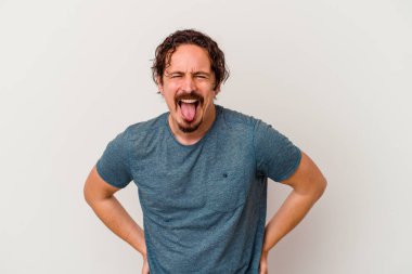 Beyaz arka planda izole edilmiş genç beyaz bir adam. Komik ve dost canlısı bir dil uzatıyor..