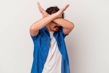 Beyaz arka planda izole genç beyaz adam iki kolu çapraz tutuyor, inkar kavramı.