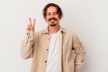 Beyaz arka planda izole edilmiş genç beyaz adam iki numarayı parmaklarıyla gösteriyor..