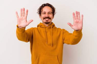 Beyaz arka planda izole edilmiş beyaz tenli genç adam on numarayı elleriyle gösteriyor..