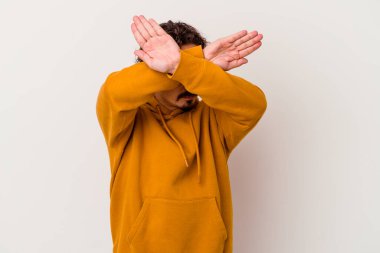 Beyaz arka planda izole genç beyaz adam iki kolu çapraz tutuyor, inkar kavramı.