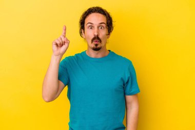 Sarı arka planda izole edilmiş beyaz bir adam ağzı açık bir şekilde üst tarafı işaret ediyor..