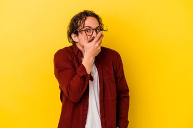 Sarı arka planda izole edilmiş genç beyaz adam korkmuş ve korkmuş..
