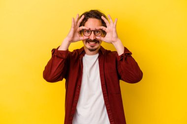 Kafkasyalı genç adam sarı arka planda izole edilmiş. Heyecanlı..