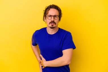 Sarı arka planda karaciğer ağrısı çeken, karnı ağrıyan genç beyaz bir adam..