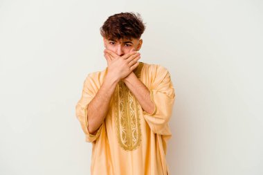 Faslı genç bir adam beyaz arka planda izole edilmiş, ağzı kapalı ve elleri endişeli görünüyor..