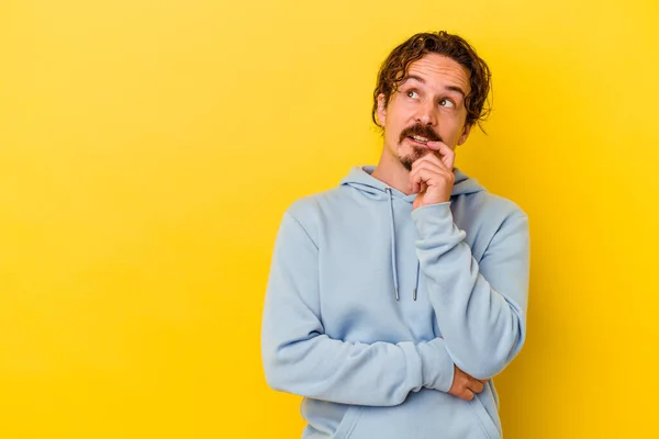 Young Caucasian Man Isolated Yellow Background Relaxed Thinking Something Looking — Stock Photo, Image