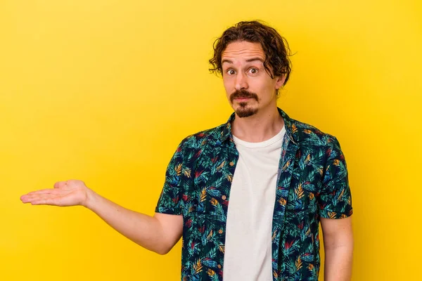 Joven Hombre Caucásico Aislado Sobre Fondo Amarillo Mostrando Espacio Copia — Foto de Stock