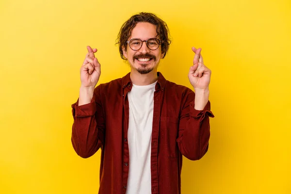 Young Caucasian Man Isolated Yellow Background Crossing Fingers Having Luck — Stock Photo, Image