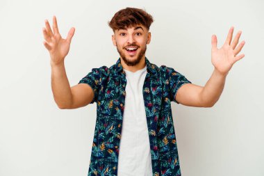 Genç Faslı bir adam beyaz arka planda zaferi ya da başarıyı kutlarken şaşırmış ve şok olmuştu..