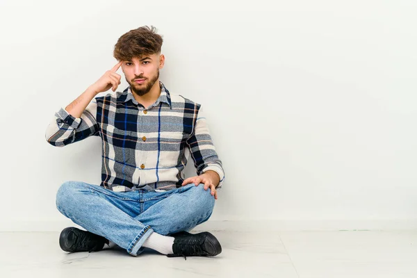 Joven Hombre Marroquí Sentado Suelo Aislado Sobre Fondo Blanco Apuntando — Foto de Stock