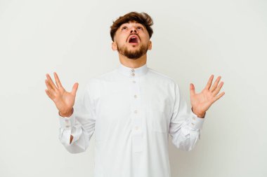Beyaz arka planda izole edilmiş tipik bir Arap kıyafeti giyen genç Faslı adam gökyüzüne haykırıyor, bakıyor, hayal kırıklığına uğruyor..