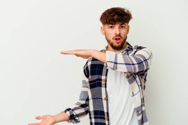 Beyaz arka planda izole edilmiş genç Faslı adam elleri arasında bir kopya alanı tutarken şok ve hayrete düştü..