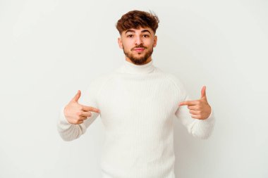 Faslı genç bir adam beyaz arka planda tek başına gömlek fotokopi alanını işaret ediyor.