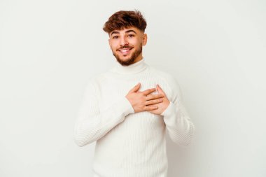 Beyaz arka planda izole edilmiş genç Faslı bir adam dost ifadesine sahip, avuçlarını göğsüne bastırıyor. Aşk konsepti.