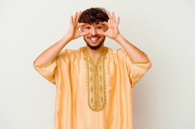 Beyaz arka planda izole edilmiş genç Faslı bir adam bir başarı fırsatı bulmak için gözlerini açık tutuyor..