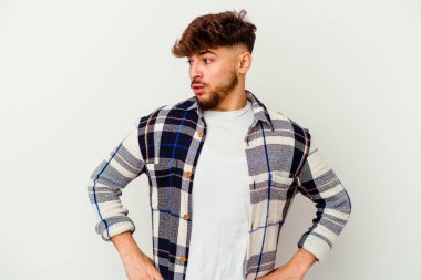 Beyaz arka planda yalnız kalmış genç Faslı adam gülümseyen, neşeli ve keyifli bir kenara bakıyor..