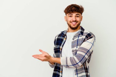 Beyaz arka planda izole edilmiş genç Faslı bir adam palmiyesinde bir kopya alanı tutuyor..