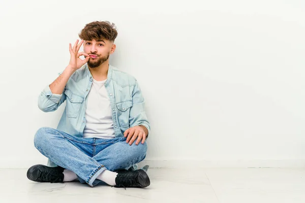 Jovem Marroquino Sentado Chão Isolado Fundo Branco Com Dedos Nos — Fotografia de Stock