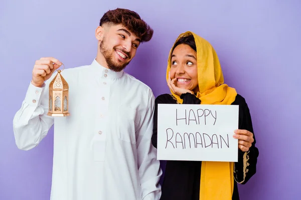 若いモロッコのカップルは紫の背景に隔離されたラマダーンを祝う典型的なアラビア語の衣装を着て — ストック写真