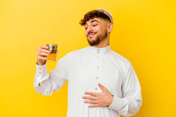 身穿阿拉伯服装的摩洛哥年轻人喝着黄色背景的茶 — 图库照片