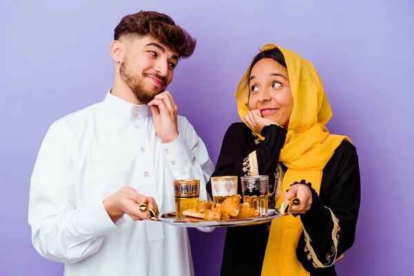 Młoda Marokańska Para Pije Herbatę Świętując Ramadan Miesiąc Izolowany Fioletowym — Zdjęcie stockowe