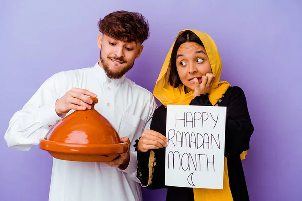 若いモロッコのカップルは紫の背景に隔離されたラマダーンを祝う典型的なアラビア語の衣装を着て — ストック写真