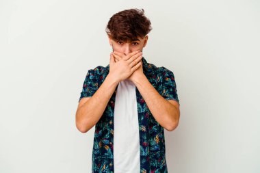 Faslı genç bir adam beyaz arka planda izole edilmiş, ağzı kapalı ve elleri endişeli görünüyor..