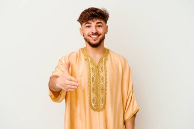 Beyaz arka planda izole edilmiş genç Faslı adam selamlaşmak için kameraya elini uzatıyor..