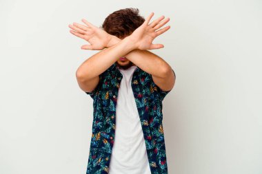 Genç Faslı bir adam beyaz arka planda izole edilmiş iki kolu çapraz tutuyor, inkar kavramı.