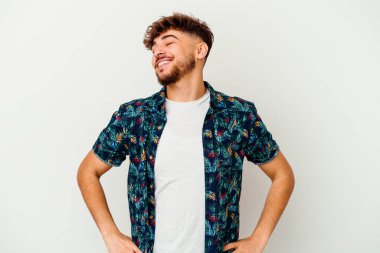 Beyaz arka planda izole edilmiş genç Faslı adam gevşemiş ve mutlu bir şekilde gülüyor, boynunda diş izleri var..