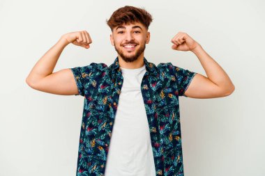 Beyaz arka planda izole edilmiş genç Faslı kadın gücünün sembolü olan kollarıyla güçlü bir hareket sergiliyor.