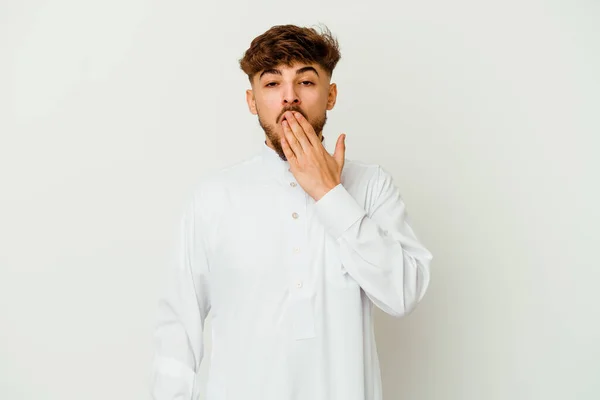白い背景に隔離された典型的なアラブ服を着ている若いモロッコ人男性は手で口を覆う疲れたジェスチャーを示しています — ストック写真