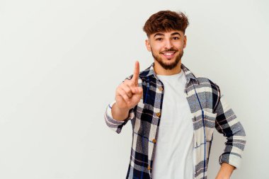 Faslı genç bir adam beyaz arka planda izole edilmiş. Parmağıyla bir numarayı gösteriyor..
