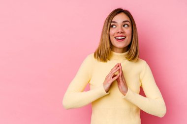 Kafkasyalı genç bir kadın pembe arka planda izole edilmiş bir plan yapıyor, bir fikir kuruyor..