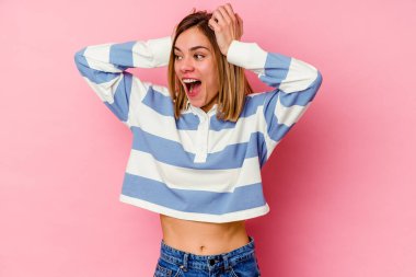 Pembe arka planda izole edilmiş genç beyaz kadın çığlık atıyor, çok heyecanlı, tutkulu, bir şeyden memnun..