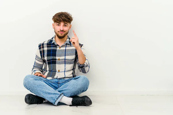 Young Moroccan Man Sitting Floor Isolated White Background Showing Number — Stock Photo, Image