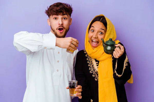 Młoda Marokańska Para Pije Herbatę Świętując Ramadan Miesiąc Izolowany Fioletowym — Zdjęcie stockowe