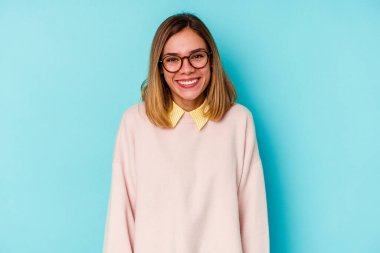 Genç beyaz kadın, mavi arka planda izole edilmiş mutlu, gülümseyen ve neşeli..
