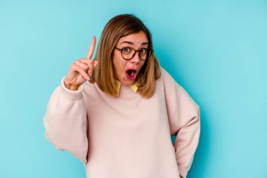 Kafkasyalı genç bir kadın mavi arka planda izole edilmiş. Bir fikri, ilham verici bir fikri var..