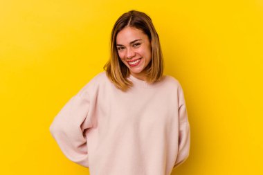 Sarı arka planda izole edilmiş genç beyaz kadın mutlu, güler yüzlü ve neşeli..