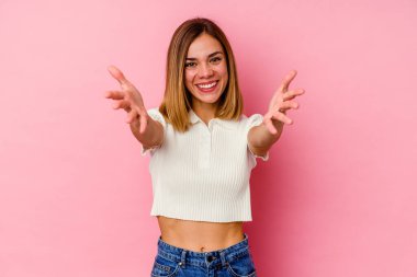 Pembe arka planda izole edilmiş genç beyaz kadın kameraya sarıldığı için kendinden emin..