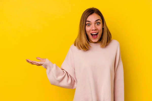 Giovane Donna Caucasica Magra Isolato Sfondo Giallo Impressionato Tenendo Spazio — Foto Stock