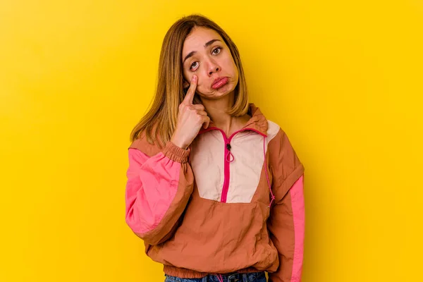 Young caucasian skinny woman isolated on yellow background crying, unhappy with something, agony and confusion concept.