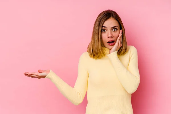 Joven Mujer Caucásica Aislada Sobre Fondo Rosa Impresionado Sosteniendo Espacio — Foto de Stock