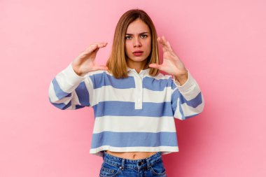 Pembe arka planda izole edilmiş beyaz bir kadın elinde avuç içi bir şeyle kameraya sunuyor..